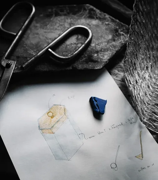Croquis de flacon Ex Nihilo entouré d'outils et de verre travaillé