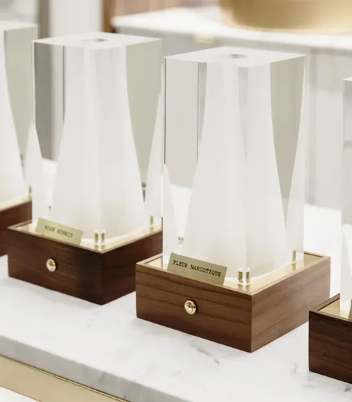 Présentoirs blancs Ex Nihilo sur socles de bois et marbre
