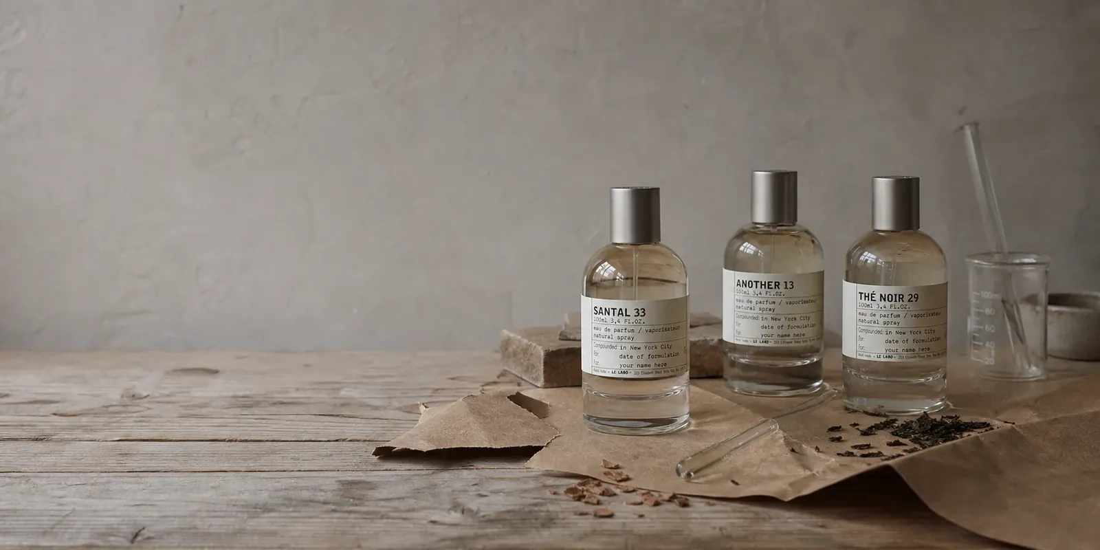 Trois flacons inspirés de Le Labo sur un établi de parfumeur