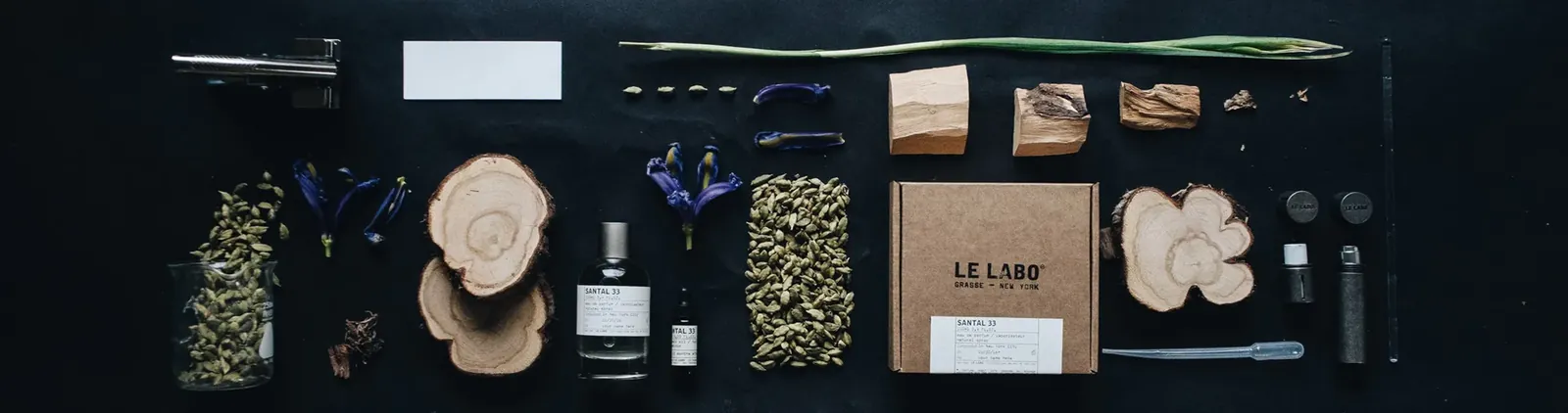 Flacon Santal 33 entouré de bois, cardamome et iris