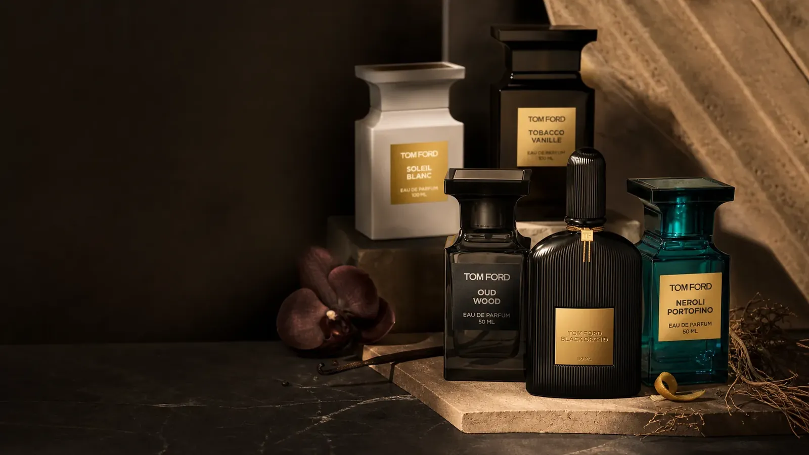 Flacons Tom Ford dans une composition sombre aux reflets ambrés